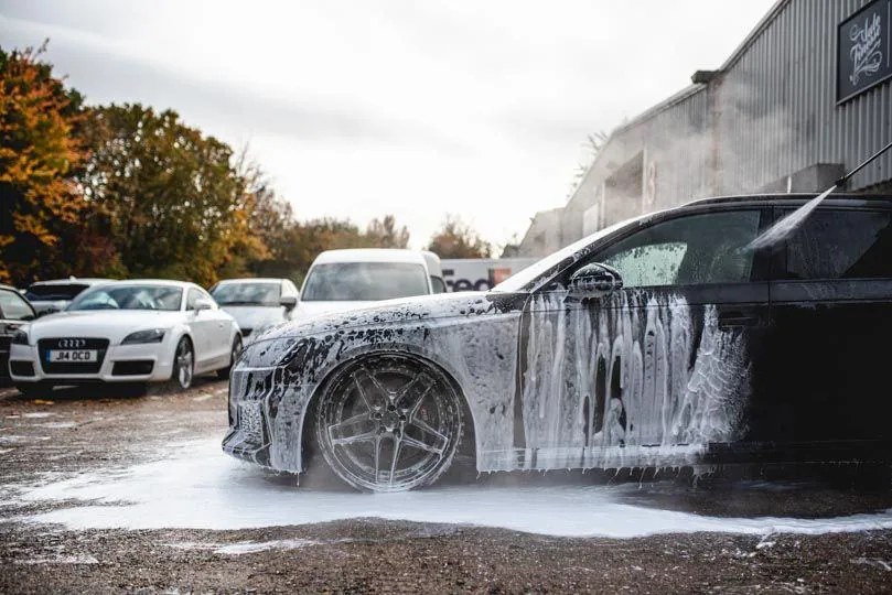 Sports car covered in white foam during an express wash