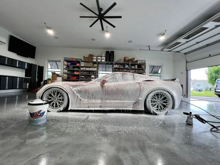 Foam-covered sports car in a detailing garage