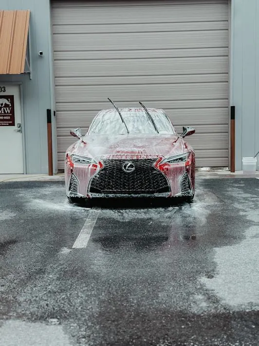 Lexus covered in foam outside a garage
