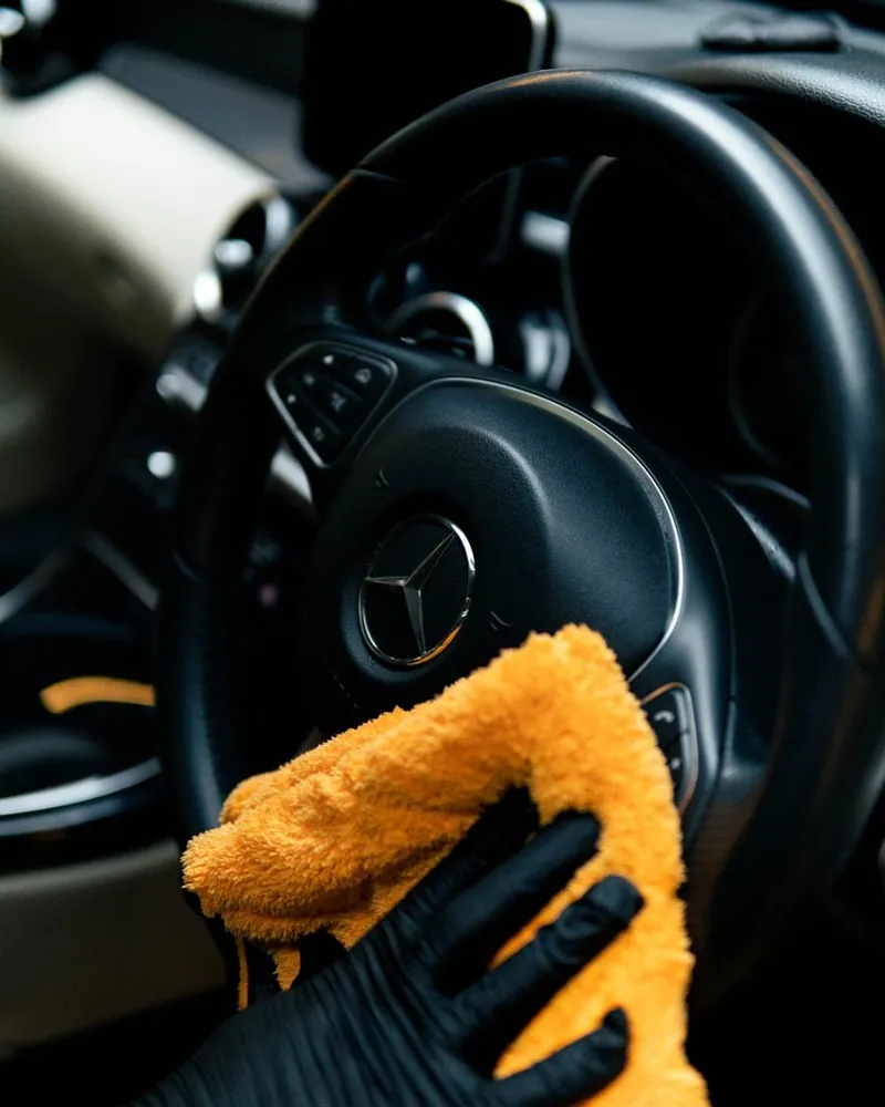 Microfiber cloth cleaning a steering wheel